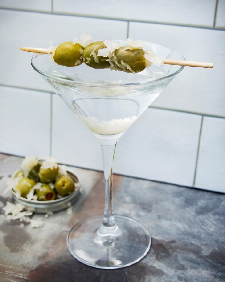 A martini glass with jumbo olives and kraut as garnish