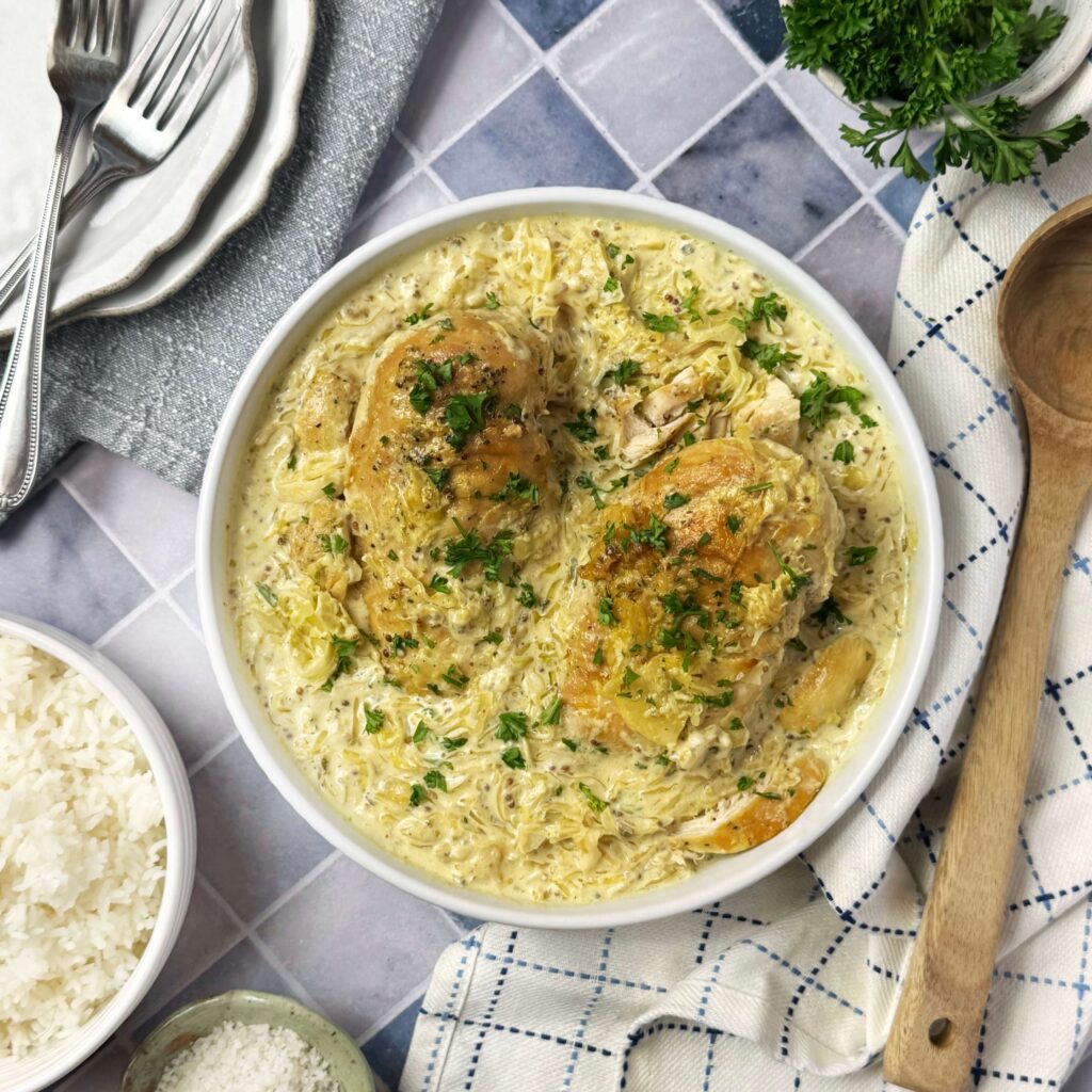 A white plate with Slow Cooker Creamy Chicken with Mustard Kraut.