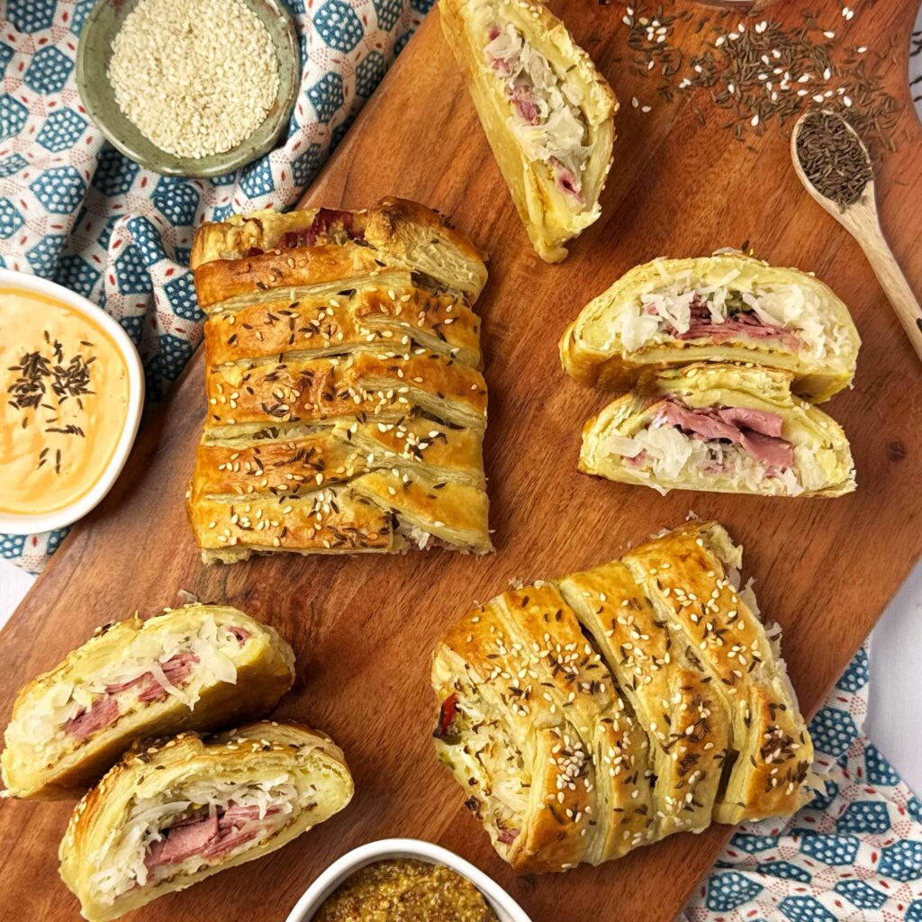 A cutting board with Reuben Strudel with Frank's kraut.