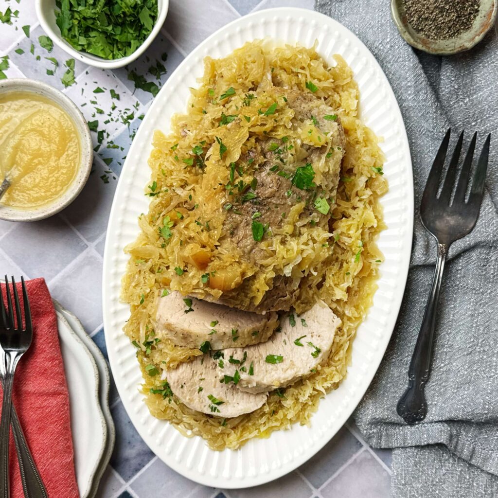 A white oval plate with Mustard Kraut and Slow Cooker Pork Loin on it.