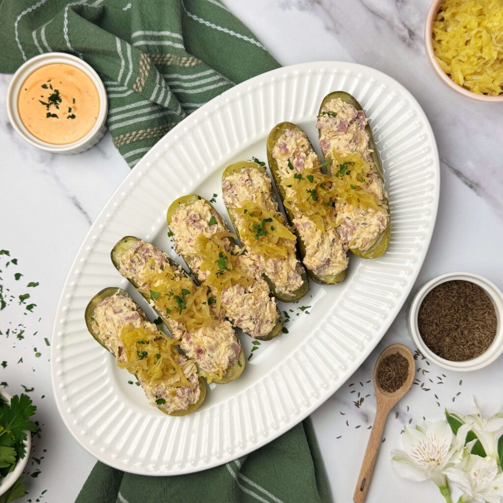 A plate with Reuben Pickle Boats and dipping sauces.