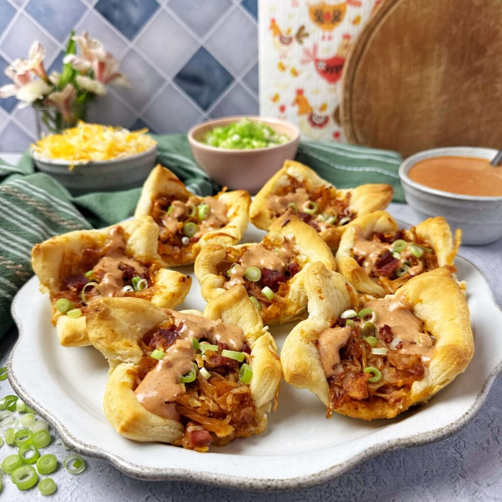 A serving plate filled with BBQ Reuben Crescent Cups.