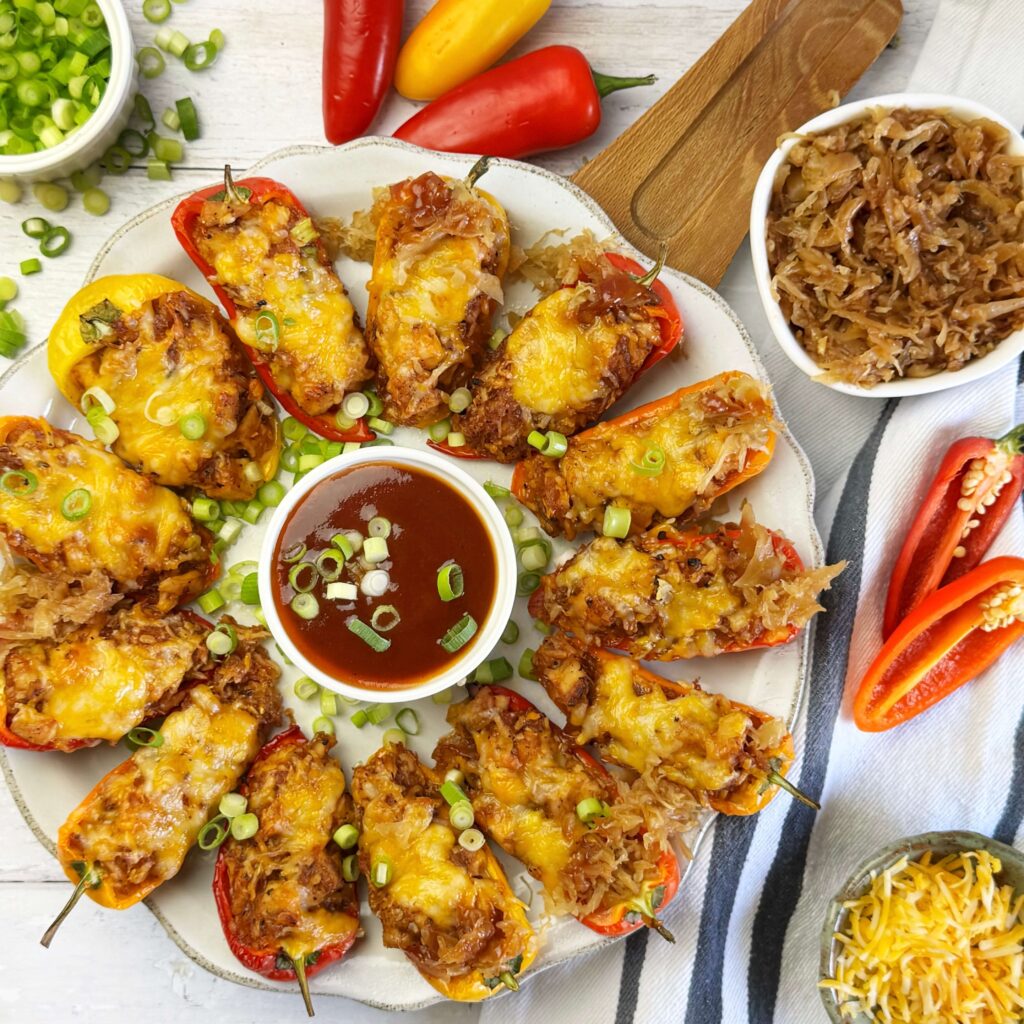 A white dinner plate with Baked BBQ and Kraut Stuffed Mini Peppers.